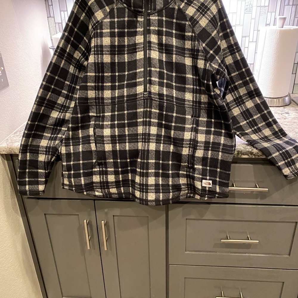 This is a pull over north face jacket plaid half a zip with a hoodie